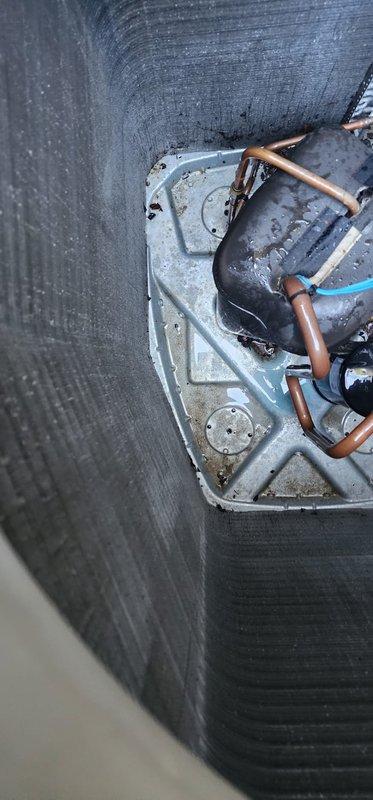 Completed comprehensive cooling season maintenance on residential air conditioning system under Worry Free Service Agreement. Performed standard AC tune-up procedures including inspection of outdoor condenser unit, which revealed moderate debris accumulation of leaves, twigs, and organic matter around base and lower panels requiring removal. Cleaned exterior coil fins and removed vegetation growth from unit perimeter to restore proper airflow. Inspected interior components including evaporator coil section, refrigerant lines, and condensate drain pan. Found standing water and moisture accumulation in drain pan with visible dirt and debris buildup. Cleared condensate drainage system and cleaned drain pan to prevent potential clogs and microbial growth. Verified copper refrigerant lines showed normal patina with no visible leaks or damage. Checked all electrical connections, capacitor operation, and compressor performance. System operating within normal parameters upon completion of main