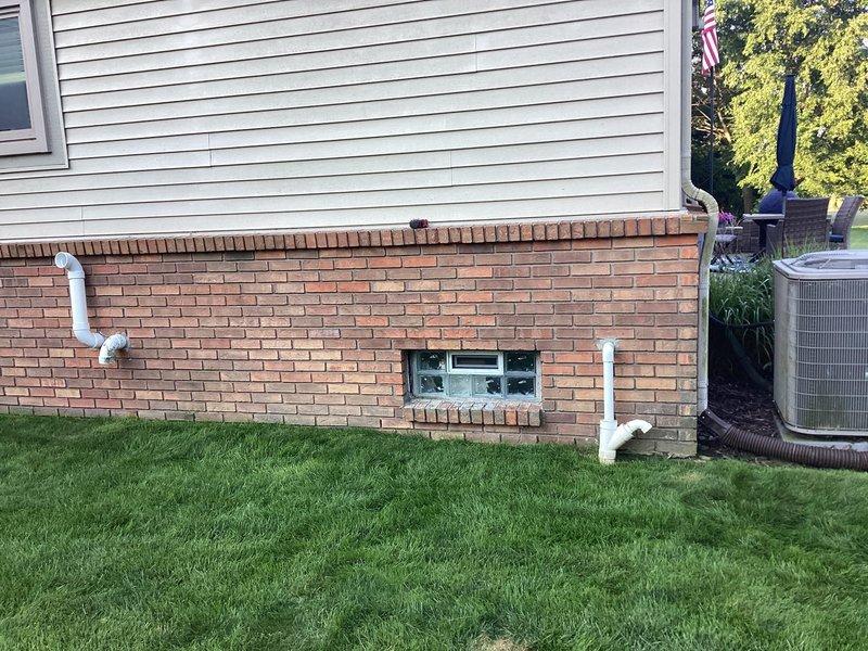 Performed site evaluation for outdoor unit relocation request to move condensing unit 15-20 feet from current location. Documented existing installation including unit placement on concrete pad adjacent to foundation, electrical disconnect box mounting, and surrounding landscape conditions. Provided assessment for disconnect and reconnect procedures with and without warranty service plan options, pending customer decision to schedule relocation work.