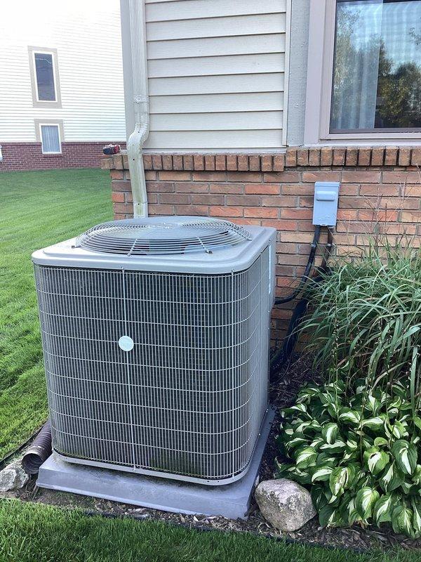 Performed site evaluation for outdoor unit relocation request to move condensing unit 15-20 feet from current location. Documented existing installation including unit placement on concrete pad adjacent to foundation, electrical disconnect box mounting, and surrounding landscape conditions. Provided assessment for disconnect and reconnect procedures with and without warranty service plan options, pending customer decision to schedule relocation work.
