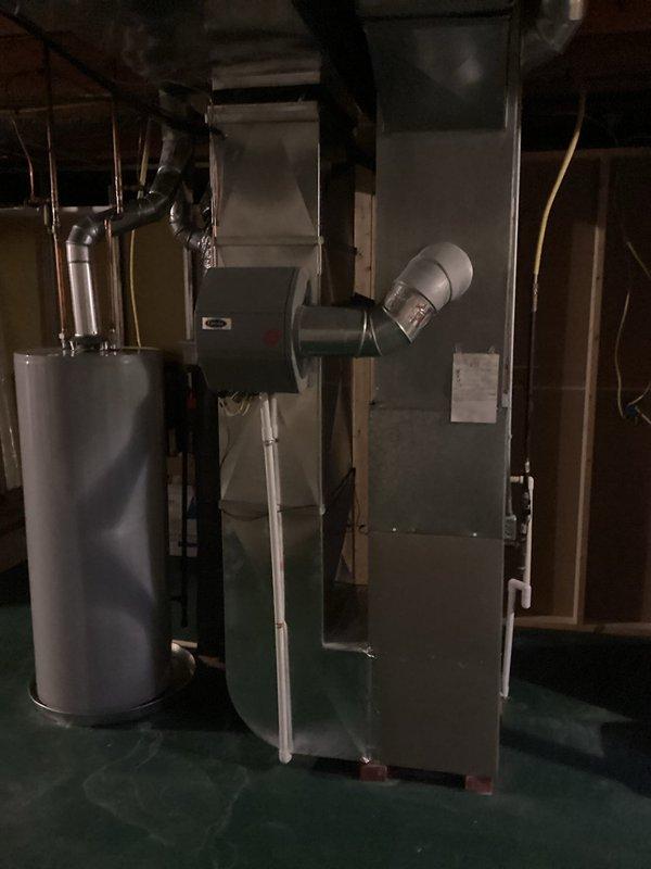 Completed comprehensive replacement estimate for 22-year-old original HVAC system in residential basement mechanical room. System remains operational but has reached end of expected service life. Documented existing furnace/air handler configuration, ductwork layout, and clearances. Photographed current equipment specifications, venting arrangement, and surrounding mechanical infrastructure including water heater proximity and available workspace for replacement installation.