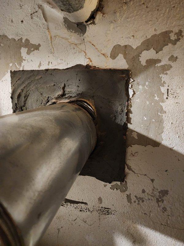 Completed callback to address failed inspection related to damaged canvas and assess water heater venting compliance. Inspected chimney liner and IVC (induced vent combustion) configuration for water heater installed by another contractor. Documented deteriorated wall penetration showing extensive peeling, flaking, and water damage around metal flue pipe, with exposed substrate material indicating long-term moisture exposure. Verified chimney cap installation on brick structure, noting weathering and biological growth on masonry. Successfully installed Lennox air conditioning system as scheduled.