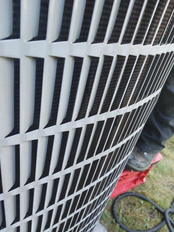 Performed routine maintenance on residential air conditioning system. Connected refrigerant manifold gauges to service ports and recorded operating pressures and temperatures, with readings showing 112.8 PSIG on low side and 260.0 PSIG on high side at 144°F. Inspected outdoor condensing unit exterior condition, verified protective grille integrity, and confirmed proper system operation upon completion of maintenance procedures.