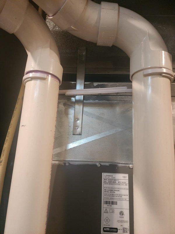# HVAC Install Warranty Completion

Responded to warranty call for mechanical failure involving compressed flexible ductwork on supply side. Upon inspection, confirmed the canvas flex duct was squished and restricting airflow at the supply plenum connection. Corrected the installation by properly positioning and securing the metallic flex duct to ensure unrestricted airflow path. Verified all duct supports and metal strapping were properly installed to prevent future compression. Inspected the complete HVAC system installation including the air handler unit, condensate drainage system with PVC piping, and all ductwork connections. Documented the corrected installation with photographs per warranty protocol requirements.