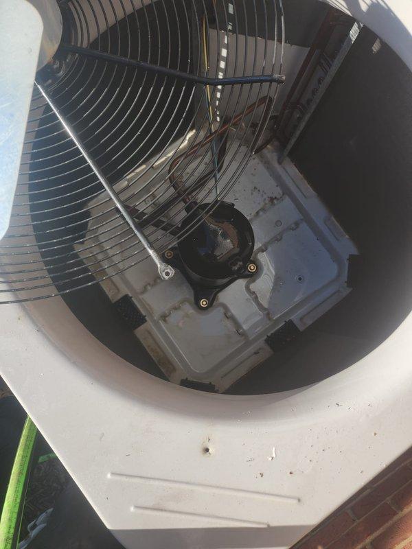 Performed comprehensive AC tune-up on outdoor condensing unit located on exterior concrete pad. Inspected condenser fan motor assembly, verified electrical connections, and checked fan blade operation. Cleaned condenser coils and exterior surfaces, removed accumulated debris from unit housing and surrounding area. Verified proper airflow through protective grilles and confirmed system operational status. Unit showed normal wear patterns consistent with regular outdoor exposure; all components functioning within manufacturer specifications at time of inspection.