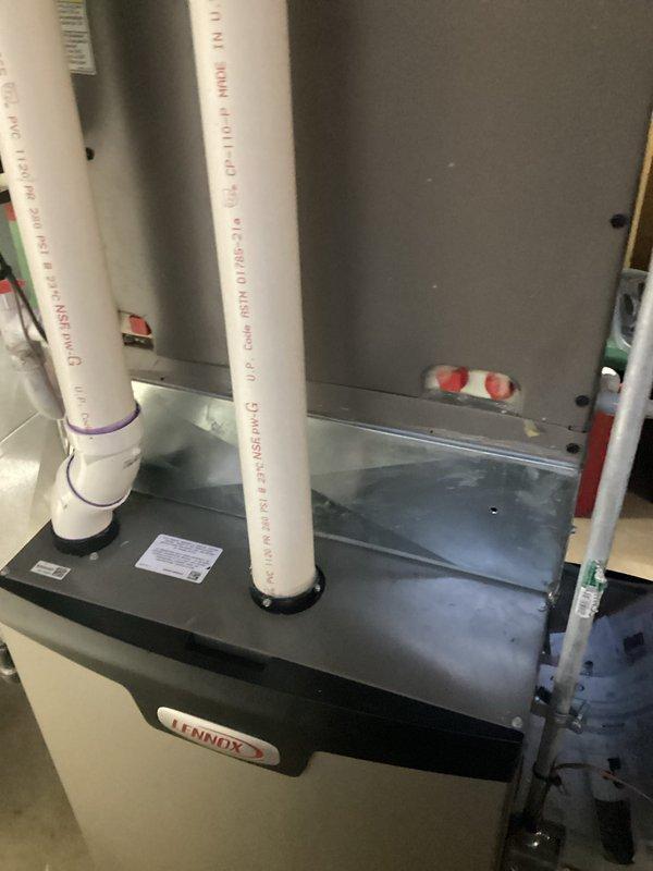 Completed comprehensive AC replacement estimate for residential split-system installation. Evaluated existing Lennox indoor air handler unit with proper PVC venting configuration and assessed two outdoor condensing units positioned along exterior brick foundation. Documented current system specifications, installation conditions, and provided replacement recommendations for complete HVAC system upgrade.