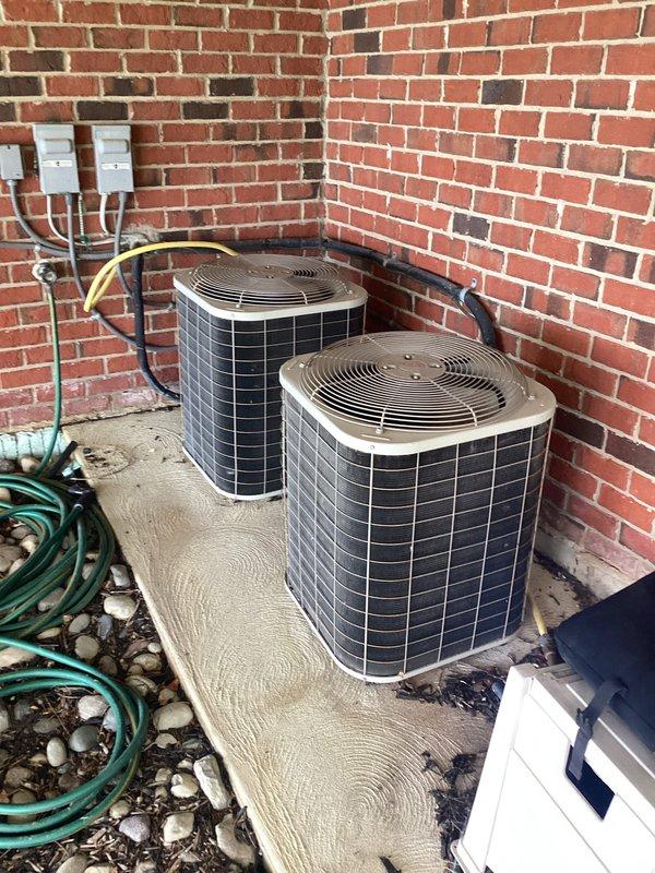 Conducted comprehensive evaluation of two outdoor HVAC systems, both exceeding 20 years of service life, following identification of failed heat exchangers in both units. Assessed the dual cylindrical condenser units positioned on shared concrete pad in exterior corner alcove, examining electrical infrastructure including disconnect switches, conduit routing, and refrigerant line connections. Documented equipment condition through detailed photography and provided replacement options for both complete system changeouts or single-unit replacement based on operational requirements and budget considerations.