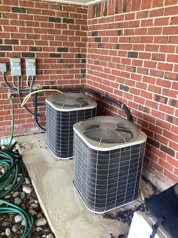 Conducted comprehensive evaluation of two outdoor HVAC systems, both exceeding 20 years of service life, following identification of failed heat exchangers in both units. Assessed the dual cylindrical condenser units positioned on shared concrete pad in exterior corner alcove, examining electrical infrastructure including disconnect switches, conduit routing, and refrigerant line connections. Documented equipment condition through detailed photography and provided replacement options for both complete system changeouts or single-unit replacement based on operational requirements and budget considerations.