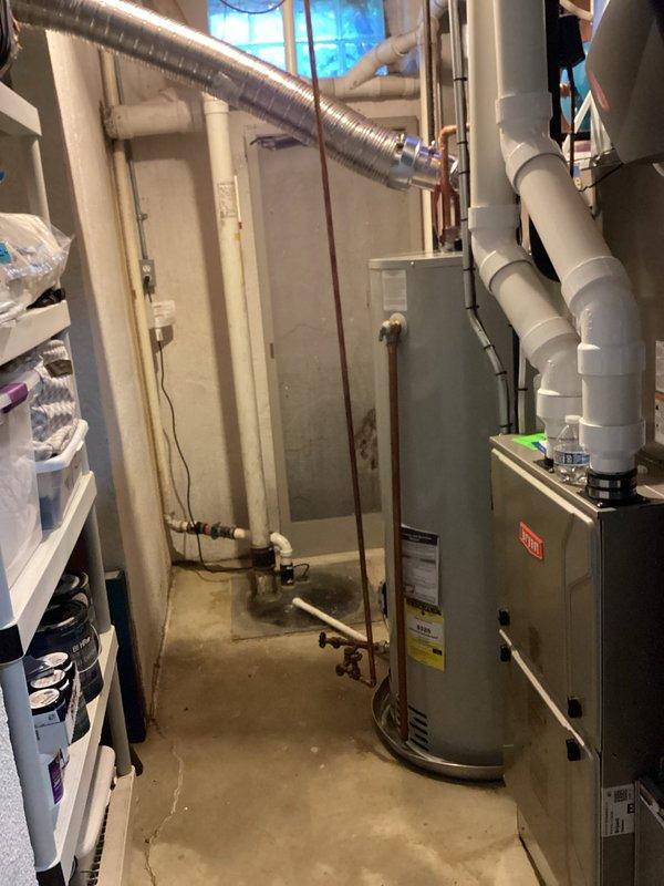 Successfully installed a 50-gallon Bradford White tanked water heater in the basement utility area. The installation included proper copper pipe connections at the base of the unit, integration with existing plumbing infrastructure, and appropriate venting with aluminum flexible ductwork featuring secure connections and proper sealing at elbow joints. The water heater was positioned to allow adequate clearance for maintenance access while coordinating with existing HVAC equipment, including the Bryant furnace, blue expansion tank, and associated PVC piping systems throughout the mechanical room.