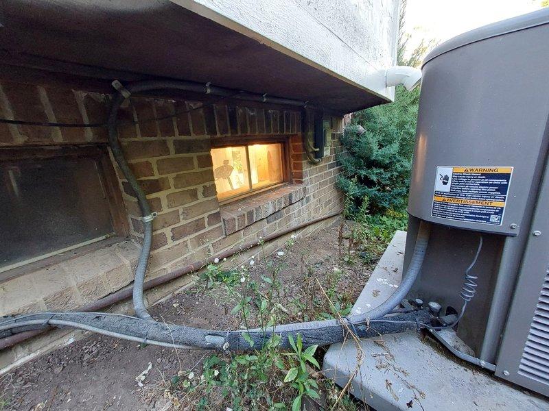 Responded to no cooling complaint for second opinion evaluation on residential HVAC system over 10 years old. Previous contractor had diagnosed refrigerant leak. Performed comprehensive system inspection of outdoor condensing unit and refrigerant line routing along building foundation. Assessed unit condition, refrigerant line integrity, and electrical connections. Documented equipment installation and surrounding area conditions for diagnostic purposes.