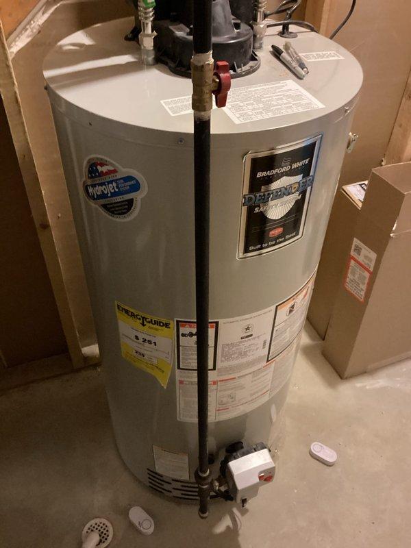 Conducted estimate for replacement of existing 11-year-old Bradford White 50-gallon Defender ND water heater currently installed in utility area. Assessed existing installation including plumbing connections, venting configuration, electrical supply, and drainage pan setup. Documented current unit specifications and photographed installation to provide accurate replacement quote for new water heater system.