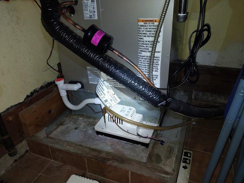 Responded to service call for condensate pump continuously running in condo unit. Upon inspection, found Bryant HVAC system with condensate drain assembly operating improperly. Diagnosed faulty condensate pump float switch causing pump to run constantly without cycling off. Tested electrical connections and verified proper drainage flow through white PVC condensate piping. Adjusted float mechanism and confirmed pump now cycles correctly with normal operation restored.