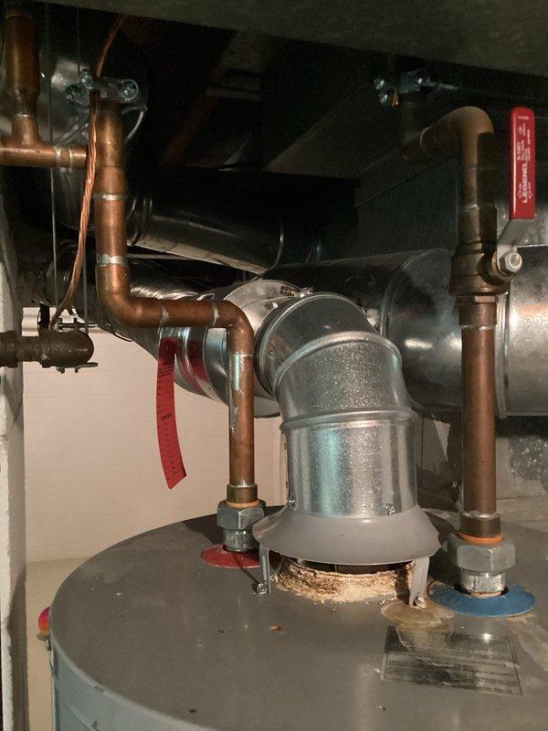 Completed comprehensive water heater estimate for existing residential hot water system. Assessed current installation featuring cylindrical water heater unit with associated copper supply and discharge piping, expansion tank, and connection infrastructure. Documented existing plumbing configuration including vertical and horizontal copper pipe runs with soldered joints, isolation valves, and mounting platform. Photographed complete system layout, mechanical connections, HVAC integration, and basement utility area conditions to provide detailed scope for water heater replacement proposal.