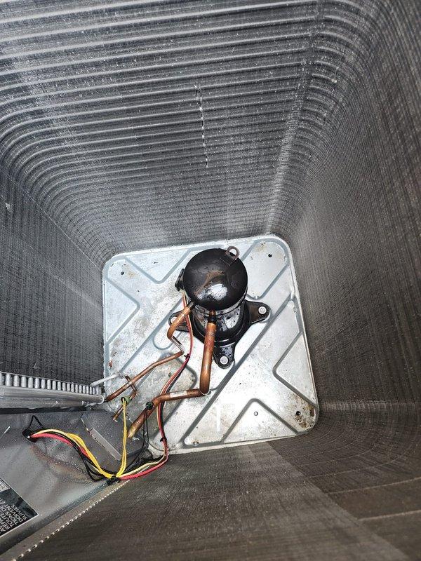Completed routine maintenance on residential air conditioning system as part of prepaid service plan. Inspected outdoor condenser unit, noting accumulated debris around base and dust buildup on aluminum cooling fins. Examined compressor assembly and refrigerant lines with service ports intact. All major components operational with no immediate issues identified during inspection.
