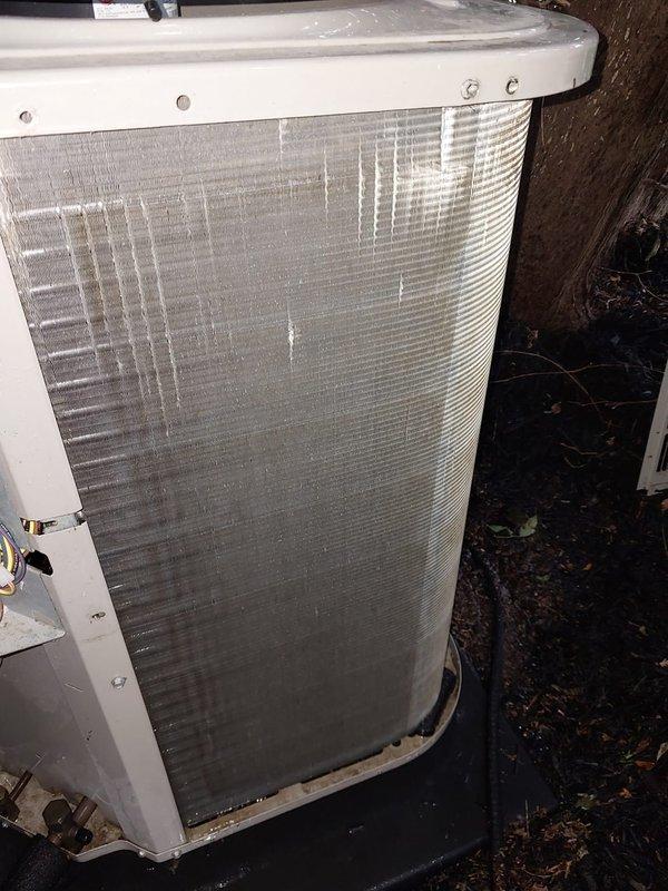 Completed scheduled cooling season preventive maintenance on residential air conditioning system. Performed comprehensive inspection of outdoor condenser unit, noting weathered coil fins with debris accumulation and vertical staining patterns indicating extended outdoor exposure, minor corrosion present at base cabinet junction. Inspected indoor evaporator coil assembly and condensate drain pan, observed staining and mineral deposits consistent with normal system operation. Verified refrigerant lines, electrical connections, and drainage components. System operational within normal parameters upon completion of maintenance service.
