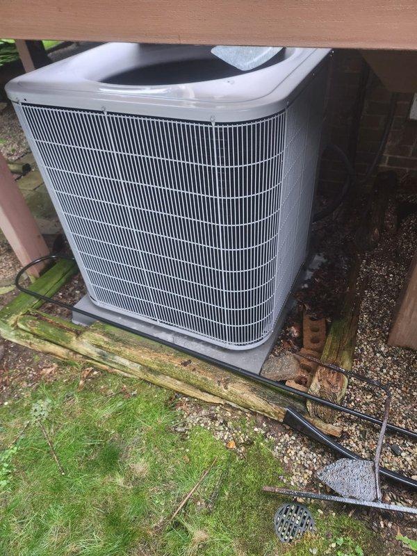 Completed preventative maintenance on residential air conditioning system under Worry Free Service Agreement. Performed system diagnostics using digital manifold gauges to verify refrigerant pressures and temperatures, confirming proper operating parameters. Inspected outdoor condenser unit, verified clean coil fins, checked electrical connections and conduit routing, and confirmed unit is properly mounted on concrete pad with adequate clearance beneath deck structure.