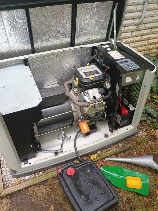 Performed scheduled maintenance on residential standby generator unit. Removed and inspected spark plugs, finding carbon buildup on one plug indicating normal combustion deposits from operation. Replaced spark plugs with new units to ensure reliable ignition and optimal engine performance. Completed oil change service, draining used oil into collection pan and refilling with fresh oil to manufacturer specifications. Verified all internal components, including air filter assembly, electrical connections, and control panel wiring for proper operation. Closed and secured cabinet panels upon completion of maintenance tasks.