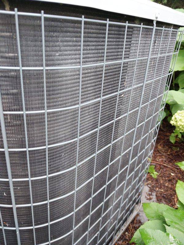 Completed comprehensive preventive maintenance inspection on residential outdoor condensing unit as part of cooling season service agreement. Unit found in good operational condition with protective wire cage intact, condenser coils clean and unobstructed, and proper airflow maintained through heat exchanger fins. Documented equipment condition with photographic records showing well-maintained installation on concrete pad with adequate clearance from surrounding landscaping.