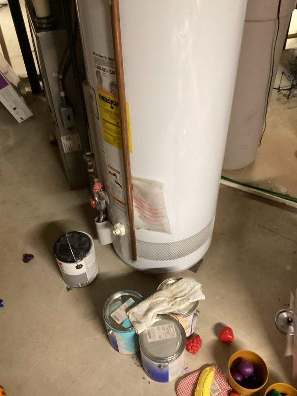 Conducted on-site assessment of existing 18-year-old residential water heater located in basement utility area. Evaluated current unit's capacity limitations and overall condition, noting standard atmospheric venting configuration with copper supply piping. Documented equipment specifications and installation environment through photographic documentation to provide accurate replacement recommendations and sizing requirements for new water heater installation.