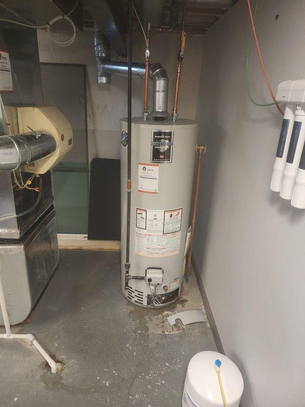 Responded to service call for hot water heater leak and loss of hot water. Upon arrival, inspected Bradford White Defender tank-style water heater in basement utility area. Identified active leak at tank requiring immediate attention. Assessed water heater condition, plumbing connections, and copper piping configuration. Due to compromised tank integrity causing the leak and hot water failure, recommended and completed water heater replacement. Installed new unit with proper copper pipe connections, pressure relief valve, and all required safety components. Tested all connections for leaks, verified proper operation of hot water system, and confirmed restoration of hot water service throughout residence.