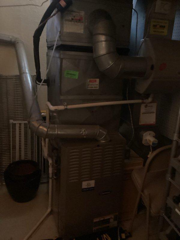 Conducted comprehensive evaluation of existing HVAC system for replacement estimate. Assessed 10-12 year old furnace and air conditioning equipment located in basement mechanical room. Documented current system configuration including beige furnace unit with metal ductwork, white AC condenser unit, expansion tank, and associated plumbing connections. Based on equipment age and overall condition, provided replacement recommendations and captured photographic documentation of existing installation for estimate preparation.