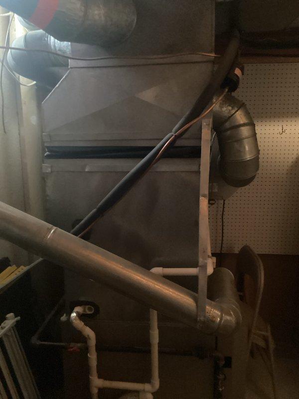 Conducted comprehensive evaluation of existing HVAC system for replacement estimate. Assessed 10-12 year old furnace and air conditioning equipment located in basement mechanical room. Documented current system configuration including beige furnace unit with metal ductwork, white AC condenser unit, expansion tank, and associated plumbing connections. Based on equipment age and overall condition, provided replacement recommendations and captured photographic documentation of existing installation for estimate preparation.