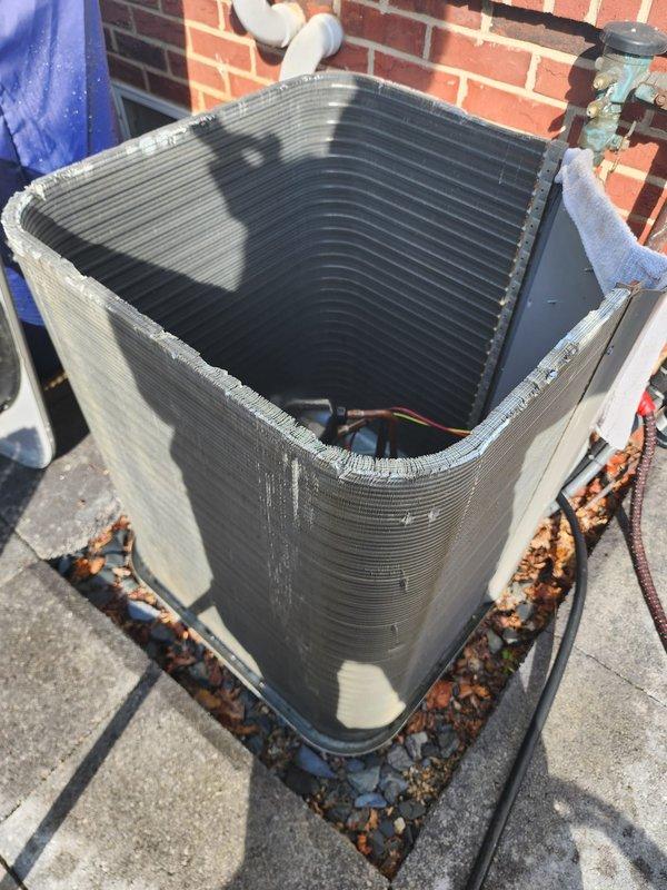 # HVAC Maintenance - Worry Free Service Agreement - Cooling

Performed comprehensive preventive maintenance on rooftop air conditioning condenser unit per Worry Free Service Agreement protocol. Conducted thorough visual inspection of outdoor condenser unit, noting significant rust accumulation and deterioration along bottom frame and base mounting pad requiring monitoring for future replacement consideration. Assessed heat exchanger coil condition, observing heavy dust and debris accumulation on aluminum fins throughout the unit, along with organic matter and dried leaves collected around base perimeter.

Inspected compressor motor and mounting hardware, documenting advanced corrosion on galvanized mounting plate and surrounding components. Verified electrical connections and wiring integrity, with red, yellow, and black conductor wires and copper refrigerant lines examined for secure connections and proper routing. Evaluated overall unit weathering and exterior surface deterioration c