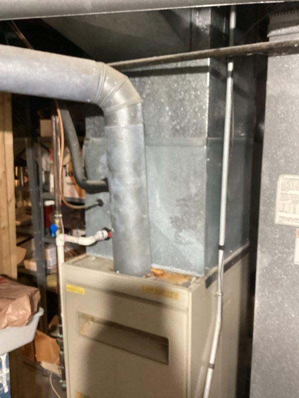 Conducted comprehensive assessment of existing HVAC system in basement installation, including furnace unit and associated ductwork. Unit confirmed to be over 10 years old with suspected clogging issues. Documented current equipment configuration, including copper refrigerant lines, PVC condensate drainage system, metallic ductwork, and furnace cabinet with filter access panel. Photographed complete installation layout for estimate preparation and replacement recommendation.