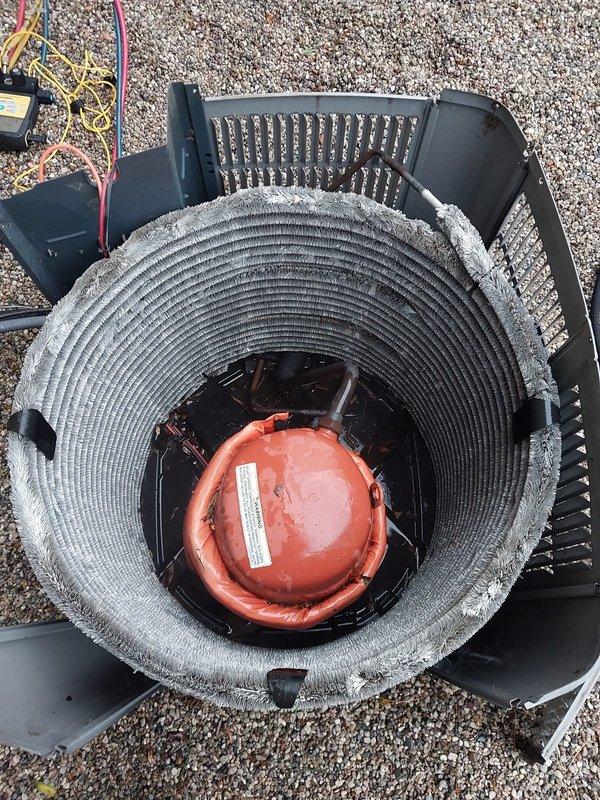 Completed preventive maintenance on outdoor condensing unit with cylindrical coil configuration. Unit exhibited severe debris accumulation on heat exchanger coil fins, with thick layers of dust, lint, and airborne particles substantially restricting airflow and reducing system efficiency. Thoroughly cleaned condenser coils to restore proper heat transfer capabilities and airflow. Inspected compressor, electrical connections, and all accessible components during maintenance service. Unit restored to optimal operating condition per Worry Free Service Agreement specifications.