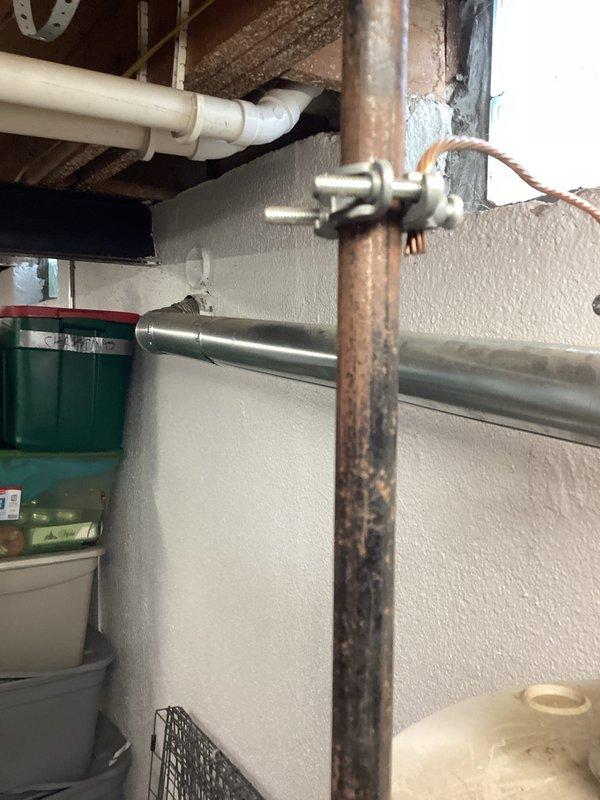 Conducted comprehensive on-site assessment for water heater replacement in residential utility space. Evaluated existing water heater unit and associated plumbing infrastructure, including copper supply lines showing oxidation and age-related wear, PVC drainage connections, and electrical connections. Documented current installation configuration, pipe routing, clearances, and accessibility for replacement equipment. Photographed existing conditions including corroded copper piping, pipe supports, and water heater positioning relative to storage areas and structural elements. Prepared detailed estimate for new water heater installation including necessary modifications to supply and discharge piping systems.
