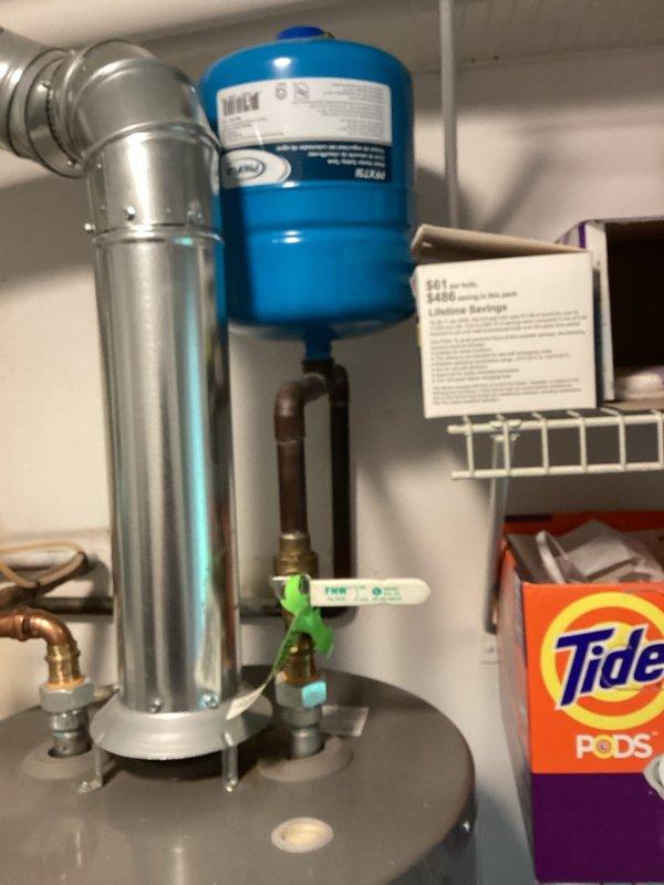 Completed estimate for water heater replacement in residential utility space. Evaluated existing water heater system with gray storage tank, blue pressure tank, copper supply lines, and metal venting configuration. Assessed current plumbing connections including brass fittings and shutoff valves. Documented equipment specifications and mechanical room layout to provide replacement options and pricing for new water heater installation.