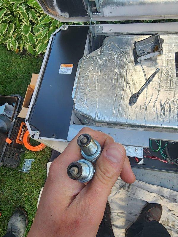 Performed routine preventive maintenance on residential backup generator system. Accessed internal components through top panel, inspected battery connections and electrical systems, and replaced spark plugs as part of scheduled maintenance protocol. All mechanical and electrical components verified operational, unit tested and secured upon completion.