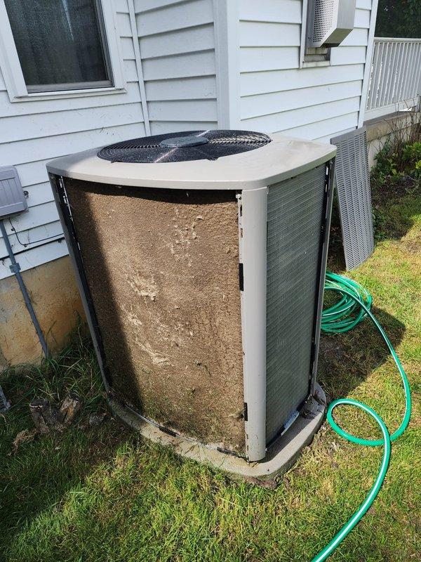 Completed comprehensive maintenance on residential split system air conditioning unit and furnace. Outdoor condenser unit exhibited severe airflow restriction due to extensive debris accumulation on coil surfaces and louver panels. Performed thorough cleaning of condenser coils, removed heavy buildup of dust, lint, and outdoor contaminants from all exterior panels and fins. Cleared obstructed airflow passages to restore proper system ventilation and heat exchange efficiency. Inspected fan assembly and motor operation. Replaced air filters on both AC and furnace systems. Conducted standard tune-up procedures including electrical connection inspection, refrigerant level verification, and overall system performance evaluation. Unit restored to optimal operating condition with significantly improved airflow capacity.
