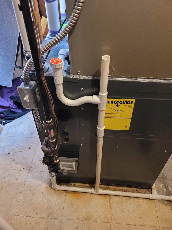 Completed installation of Bryant air conditioning system in residential basement utility room. New air handler unit was positioned and secured, with all necessary refrigerant lines, electrical connections, PVC condensate drainage, and supply ductwork properly installed and sealed to manufacturer specifications. Retrieved customer's portable air conditioning unit from premises as requested.