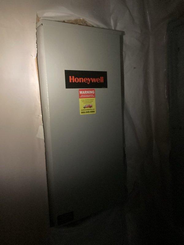Completed comprehensive estimate for replacement of storm-damaged HVAC system and generator equipment. Assessed two Bryant condenser units positioned on exterior concrete pads against brick wall, along with Honeywell indoor air handling equipment located in basement utility area, all requiring replacement due to storm damage sustained on 9-11. Documented existing equipment configuration, electrical disconnects, and structural conditions through detailed photography to support replacement specifications and scope of work.