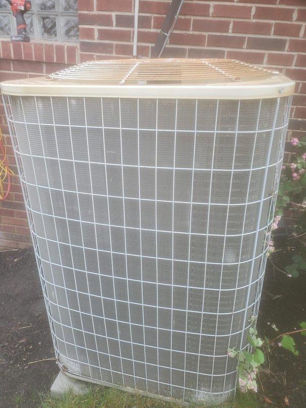 Completed comprehensive cooling system maintenance inspection under Worry Free Service Agreement. Outdoor condenser unit examined and found in operational condition with wire grille protection intact and coil fins accessible for service. Interior water heater area inspected, revealing significant rust corrosion on concrete floor surrounding tank base and mineral deposit accumulation, indicating potential moisture concerns requiring monitoring for future service considerations.