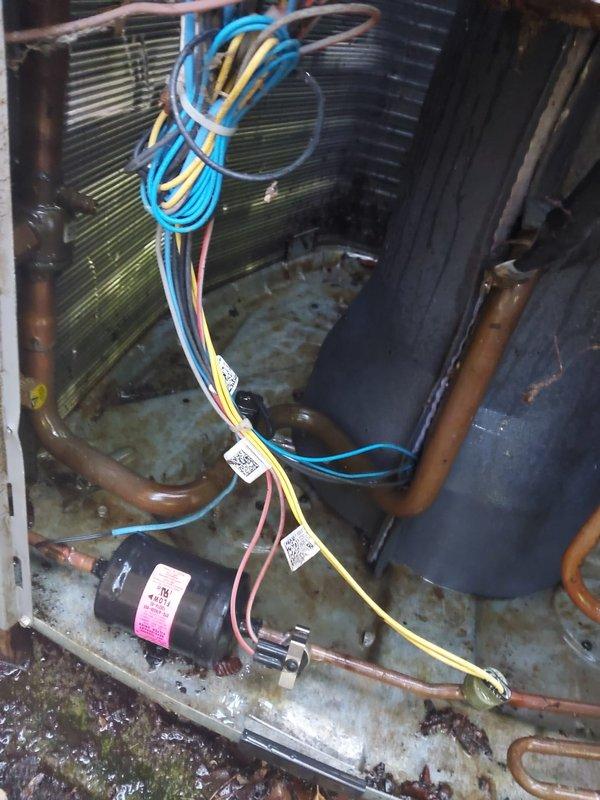 Completed comprehensive cooling season maintenance on outdoor condensing unit. Performed visual inspection of exterior cabinet, coil surfaces, and internal components including compressor, capacitor, refrigerant lines, and electrical connections. Unit showed typical weathering and debris accumulation around base and coil fins consistent with outdoor exposure. All critical components operational and system ready for cooling season demand.