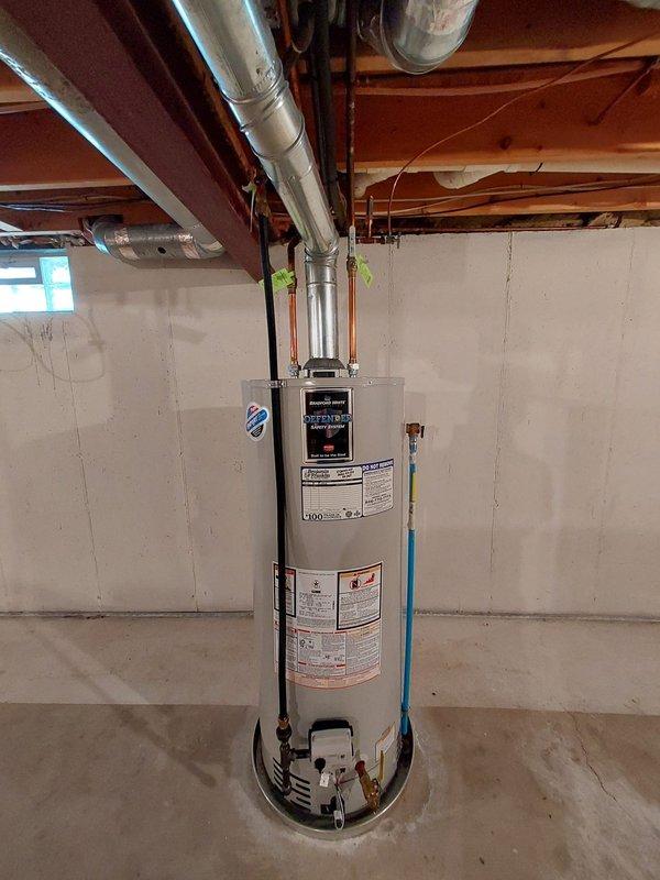 Performed routine maintenance on tanked water heater under warranty plan coverage. Conducted comprehensive inspection of unit, including examination of all manufacturer labels, specification plates, and safety warnings for compliance and readability. Verified proper operation of flue pipe connection and venting system extending to overhead ductwork. Inspected all plumbing connections at base of unit, including water supply lines, discharge piping, and gas line fittings for leaks or deterioration. Checked condition of installation platform and surrounding concrete floor for moisture or structural concerns. Confirmed proper clearances around unit and verified basement ventilation adequate for safe operation. Unit found to be functioning within normal parameters with no immediate repairs required.