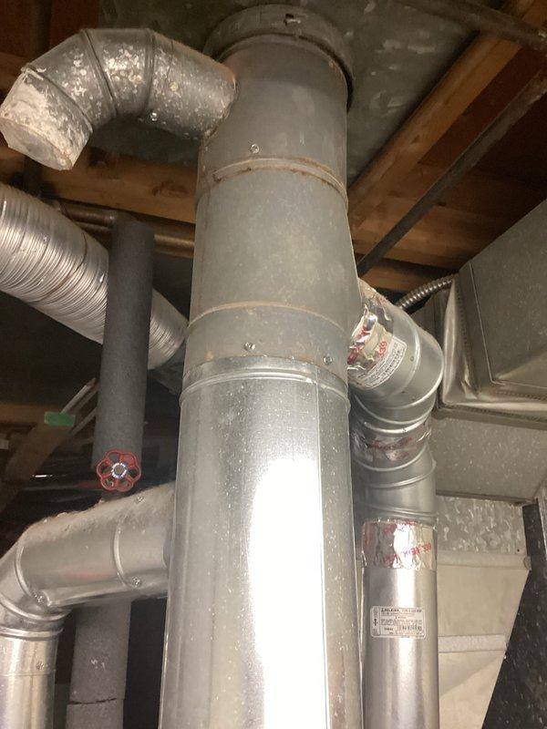 Provided estimate for replacement of 20+ year old Comfortmaker furnace system currently located in basement mechanical room. Existing natural gas furnace remains operational but has reached end of expected service life, with visible condensation on ductwork and aging components requiring replacement to ensure continued reliable heating performance.