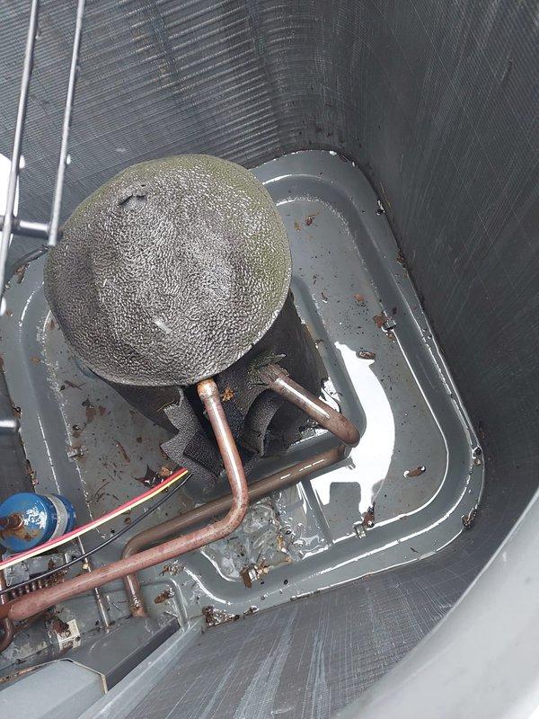 Completed comprehensive AC tune-up on 16-year-old outdoor condensing unit as part of prepaid maintenance plan. Upon inspection, discovered evaporator coil with severe ice buildup and standing water with rust accumulation in drain pan, indicating restricted airflow or refrigerant issue. Cleaned and inspected air return grille, checked all electrical connections, tested system operation, and addressed freezing condition to restore proper cooling function.