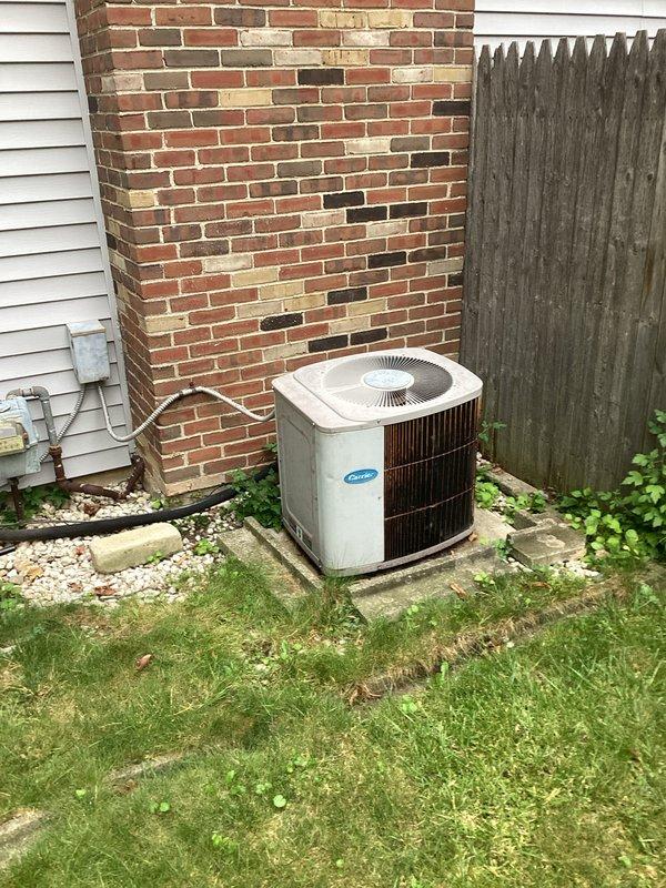 Completed on-site evaluation of non-operational central air conditioning system for full replacement estimate. Assessed existing outdoor condenser unit positioned on concrete pad against brick chimney and indoor air handler with associated ductwork, drainage lines, and heating components in mechanical closet. Documented current equipment configuration, installation conditions, and provided homeowner with comprehensive replacement options for complete HVAC system.