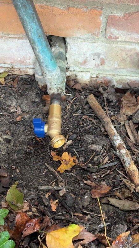 Replaced faulty ball valve on exterior hose bib connection serving garden sprinkler system. The existing brass valve showed significant wear and corrosion, preventing proper water flow control. Installed new brass ball valve with blue handle at foundation-level connection point where galvanized supply line meets PVC distribution pipe. Service completed during scheduled timeframe with photographic documentation of finished installation.