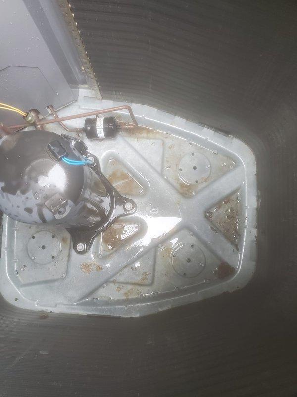 Completed preventive maintenance inspection on residential split-system air conditioning unit. Inspected indoor air handler assembly including condensate drain pan, which showed evidence of previous water accumulation with mineral deposits and staining but was functioning properly with condensate pump operational. Verified all drain line connections, float switch, and copper refrigerant lines for proper operation. Exterior condenser unit inspected on concrete pad, confirming fan guard secure, cabinet panels intact, and adequate clearance from structure maintained for proper airflow and heat dissipation.
