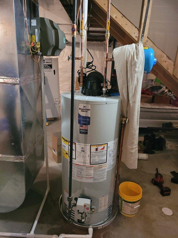 Successfully installed a 50-gallon tanked water heater in the basement utility area with all necessary connections and safety components. Replaced the defective pea fitting and installed a drain pan beneath the unit, properly plumbing the pan's discharge line into the existing drainage system to protect against potential leaks. All copper supply lines, brass fittings, and PVC drainage connections were secured according to code requirements, and the installation was tested for proper operation.
