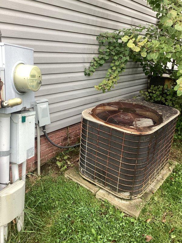 Provided estimate for complete HVAC system replacement including outdoor condensing unit and indoor furnace. Existing equipment is non-operational with age unknown; outdoor unit shows significant weathering and corrosion on exterior surfaces, while indoor gas furnace exhibits dust accumulation and signs of age in confined utility space. Recommended full system replacement to restore heating and cooling functionality.