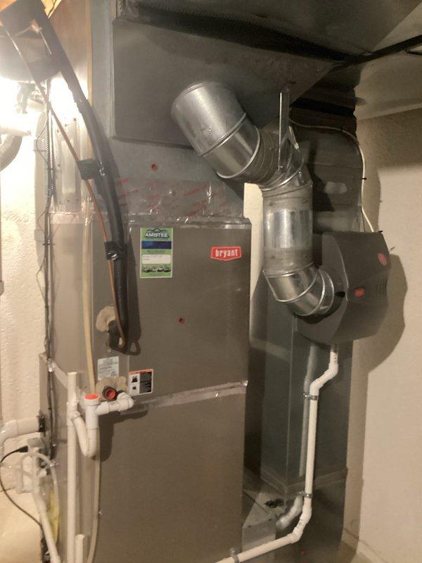 Performed comprehensive HVAC system evaluation for residential air conditioning unit experiencing low R-22 refrigerant levels. Assessed existing Bryant furnace and air handler installation in basement utility area, documenting current equipment condition including visible wear on metal casing and existing ductwork configuration with flexible and rigid metallic ducts. Evaluated condensate drainage system with white PVC piping and identified refrigerant deficiency requiring system replacement estimate due to obsolete R-22 refrigerant and equipment age. Provided replacement options for complete HVAC system upgrade to modern, energy-efficient equipment with environmentally compliant refrigerant.