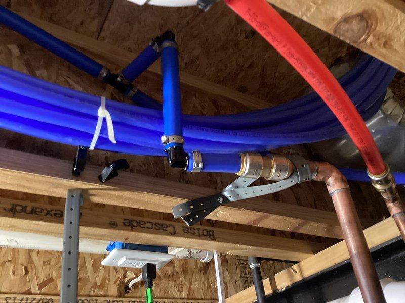 Returned to address leaking PEX connection at T-fitting near shark bite connection above water heater from previous installation. Replaced faulty PEX fitting with proper connection to eliminate slow leak. Completed installation of 50-gallon water heater with new drain pan and plumbed drain pan overflow line into existing drain system per code requirements.