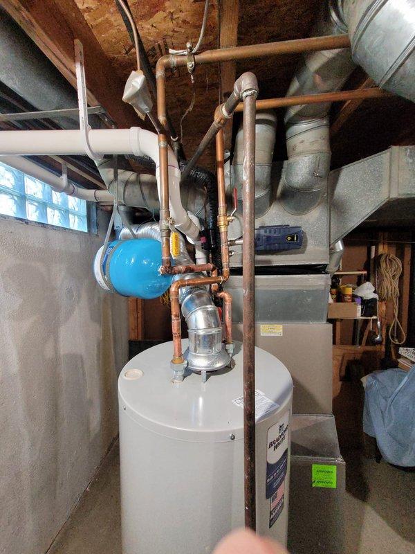 Successfully installed a new 40-gallon tanked water heater in the basement utility area. The installation included connecting copper supply piping to the unit, mounting a blue expansion tank above the water heater, and ensuring all plumbing connections were properly secured and tested for leaks. All work was completed to code specifications with the unit operational and ready for use.