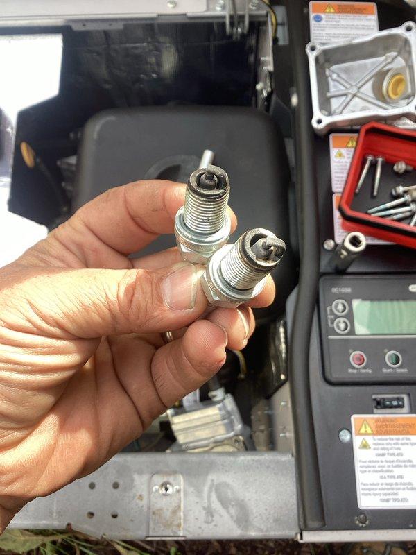 Performed scheduled maintenance on residential standby generator system. Removed and inspected spark plugs, finding normal wear consistent with operating hours. Verified all safety labels and warning placards intact and legible on unit housing. Inspected control panel display for proper function, confirming digital readout operational and system parameters within normal range. Examined electrical connections and wiring for signs of wear or damage, finding all connections secure. Documented equipment serial number and model information for service records. Unit tested and returned to operational status with all systems functioning as designed.