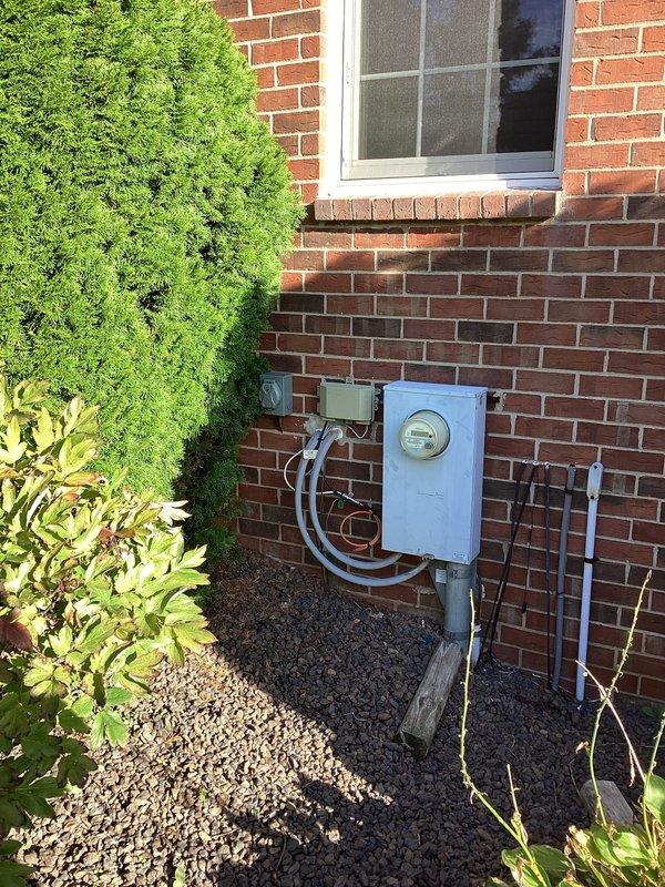 Conducted comprehensive site evaluation for residential backup generator installation. Assessed existing electrical infrastructure including outdoor meter assembly with gray conduit configuration and main service panel containing dual columns of circuit breakers with labeled circuits for various household loads including EV charging capability. Documented current electrical service entry point on brick exterior and interior panel location to determine optimal generator placement, transfer switch requirements, and necessary electrical connections for automatic standby power system integration.