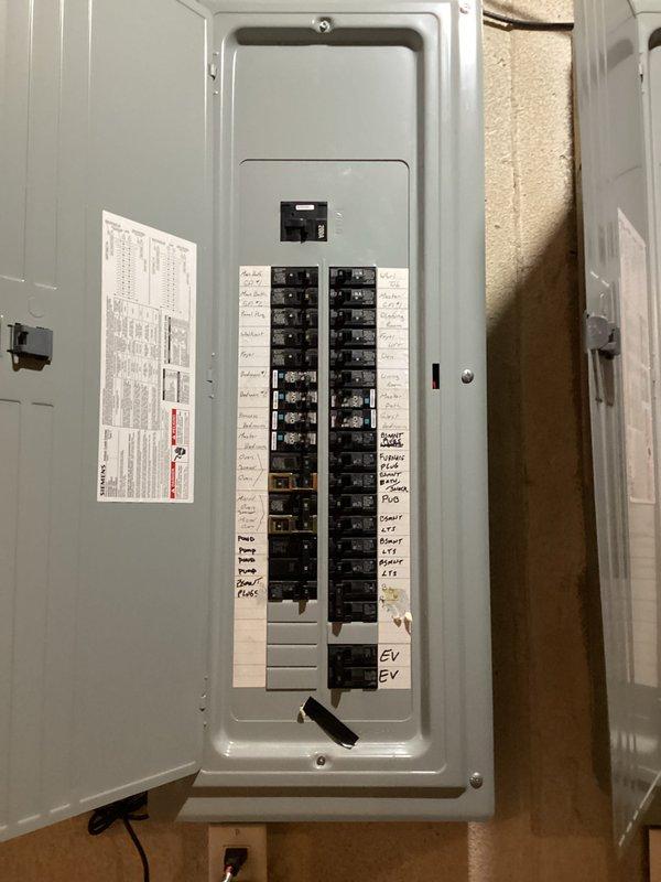 Conducted comprehensive site evaluation for residential backup generator installation. Assessed existing electrical infrastructure including outdoor meter assembly with gray conduit configuration and main service panel containing dual columns of circuit breakers with labeled circuits for various household loads including EV charging capability. Documented current electrical service entry point on brick exterior and interior panel location to determine optimal generator placement, transfer switch requirements, and necessary electrical connections for automatic standby power system integration.
